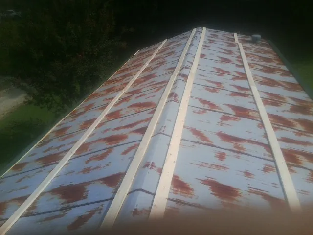 Rusted metal roof panels with new wood purlins before replacement — Storm Damage Roof Repair in Winnie by Roofing Brothers